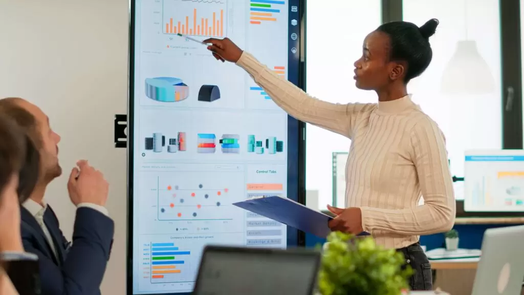A man and woman use a powerful insurance claims platform to streamline their daily workflow in a collaborative office.